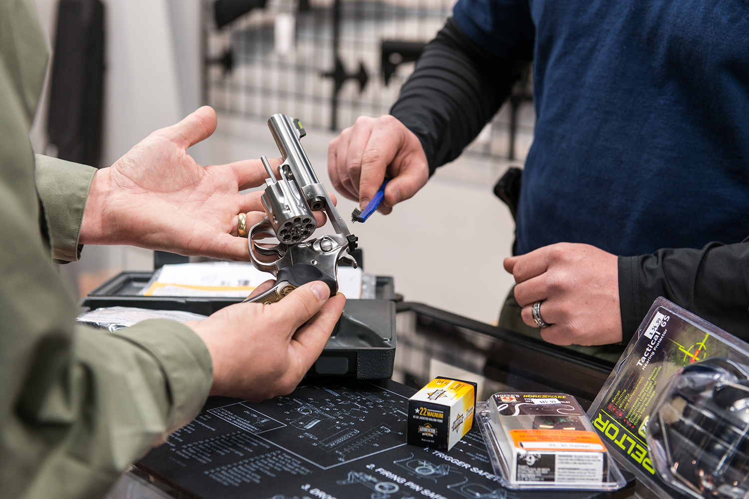 A customer looks at a handgun with an employee of the Mass Firearms School gun shop